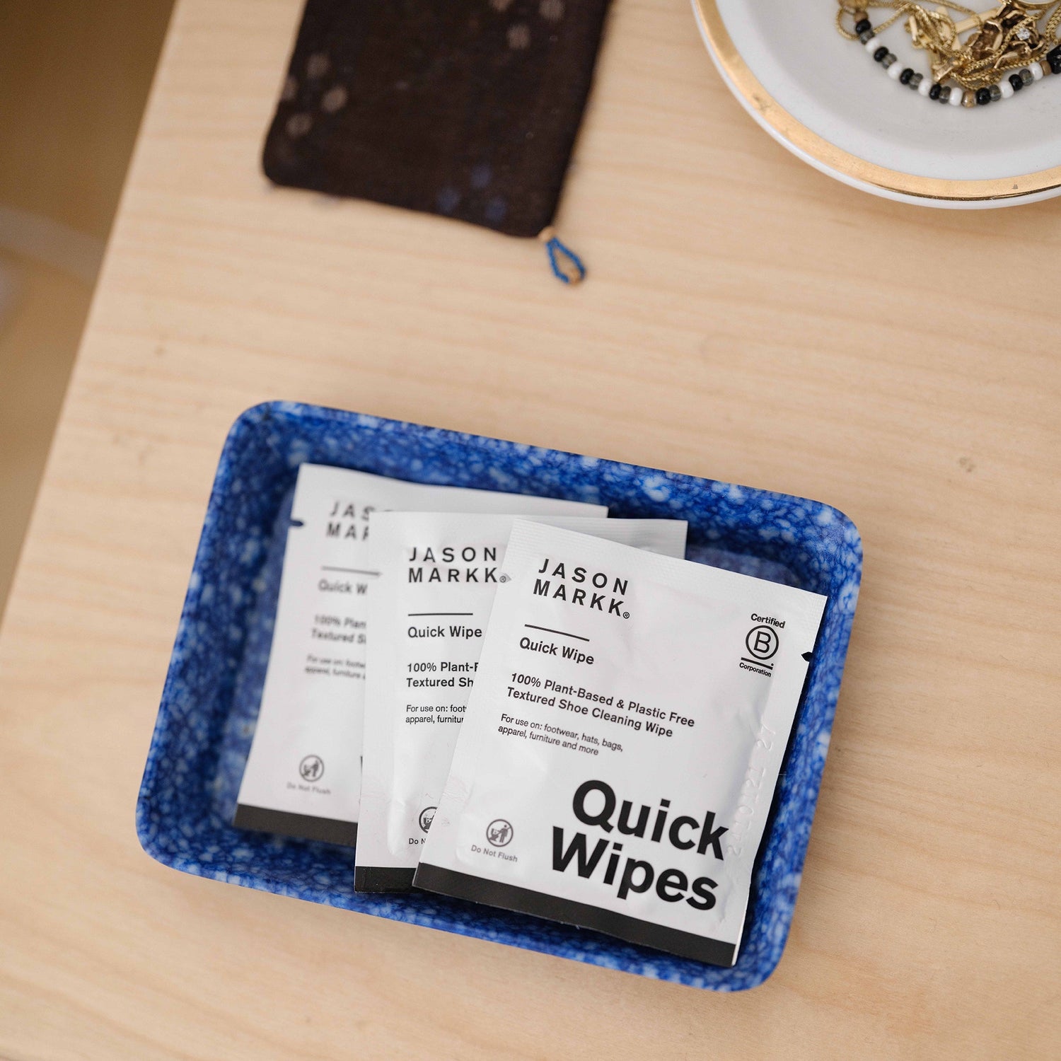 Jason Markk Quick Wipes in a blue tray on a wooden surface