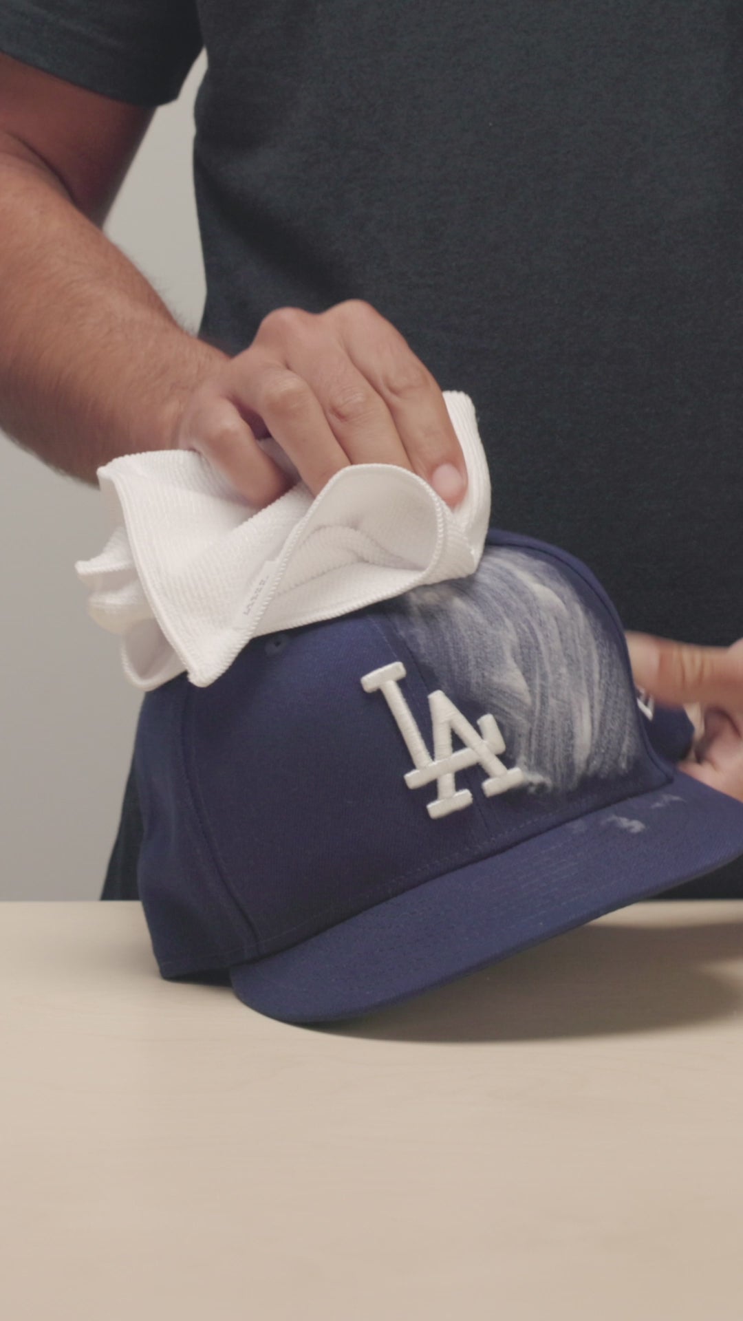 JASON MARKK MICROFIBER TOWEL WIPING A NEW ERA DODGER HAT