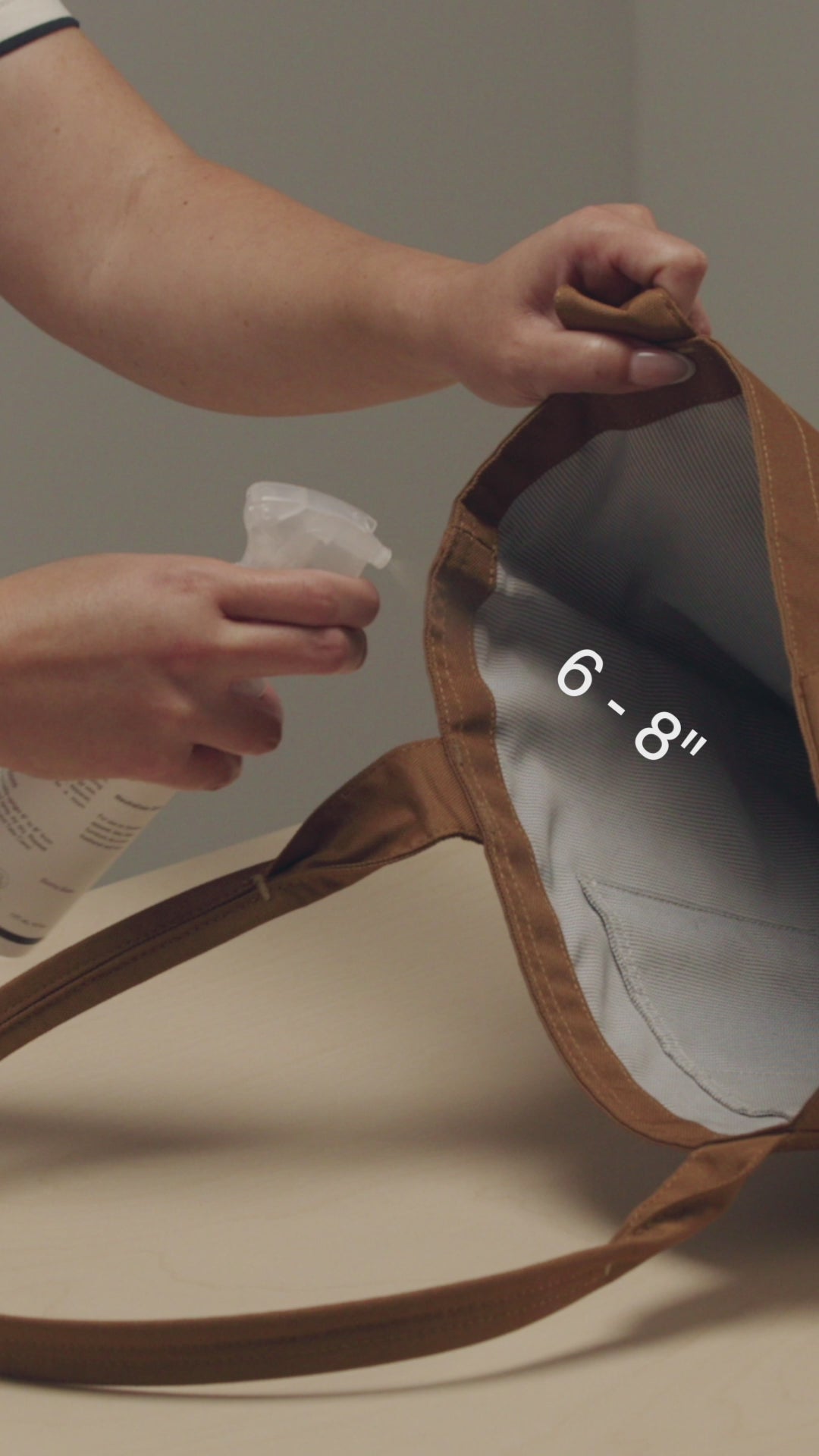 HOLD JASON MARKK REFRESH SPRAY 6 TO 8 INCHES FROM CARHARTT TOTE BAG