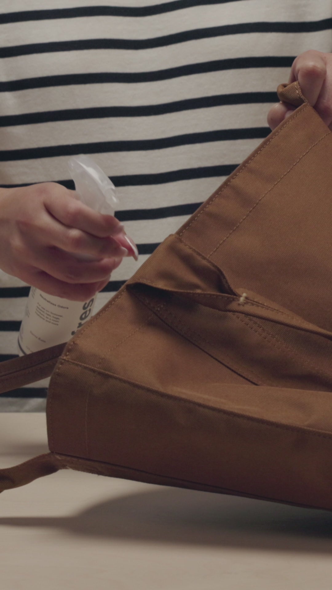 APPLYING JASON MARKK REFRESH SPRAY ON A CARHARTT TOTE, RED EBBETS CAP, VISVIM DENIM JACKET AND ASICS KAYANO